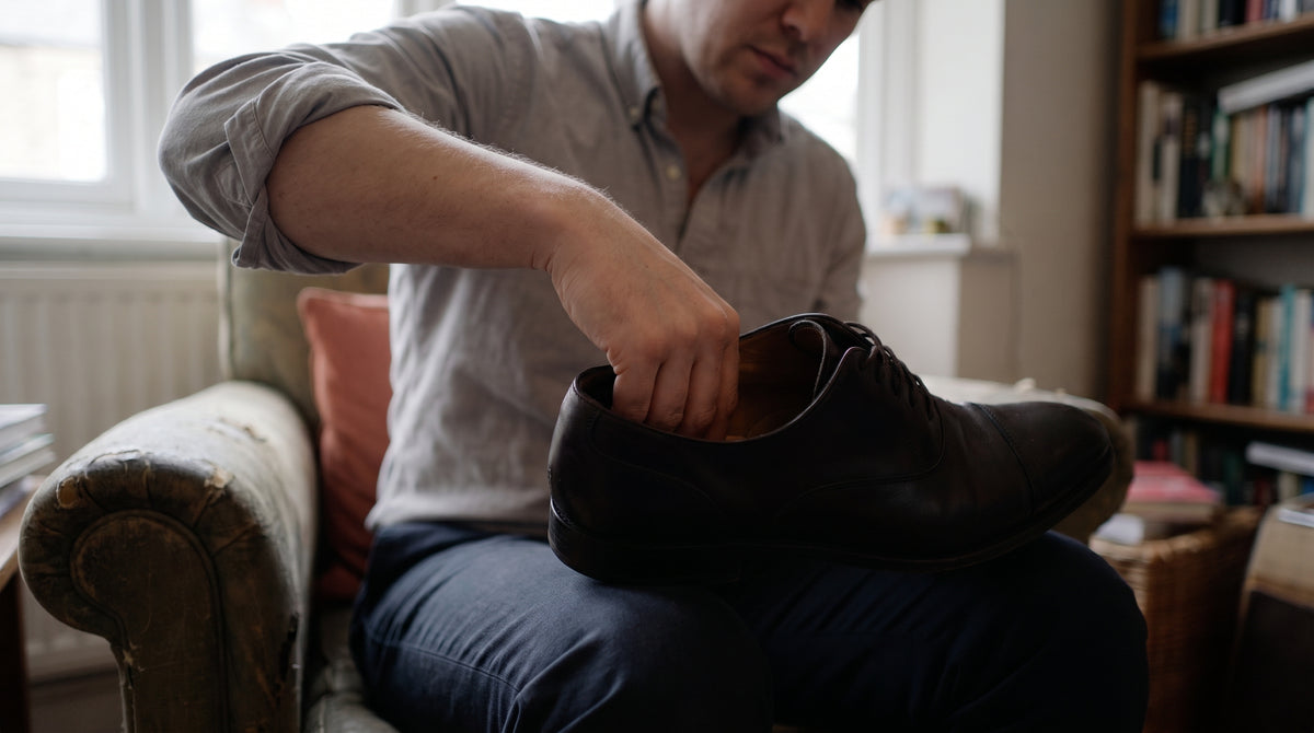 Close-up of a hand adjusting a shoe to fit tighter at the heel